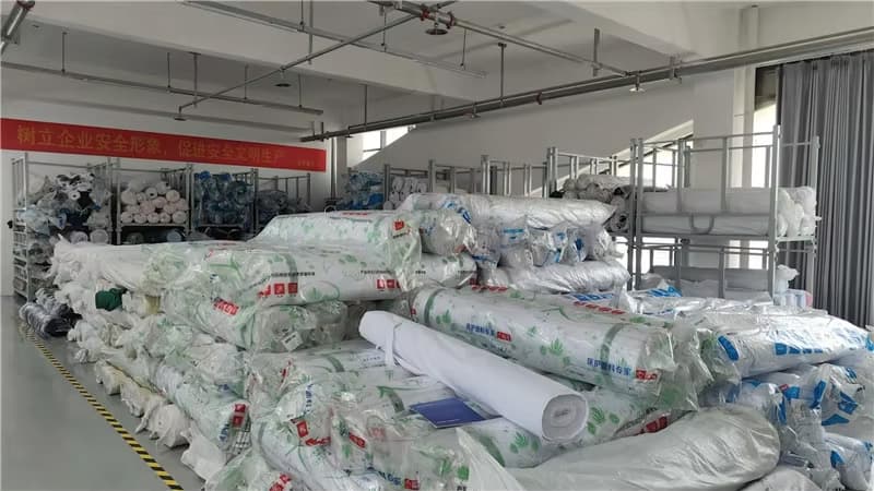 Fabric rolls stored in the raw-material area at Xiangfeng’s Henan production facility